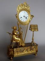 Pendule d'époque Empire en bronze redoré à décor d'une harpiste,...
