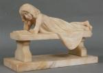 140 - Fillette allongée sur un banc, lisant. Albâtre sculpté,...