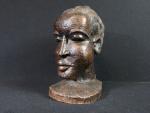 Tête africaine d'époque coloniale en bois. (usures) H. : 35cm...