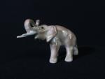 Un éléphant en porcelaine de Limoges (H. : 8cm). (Usures...