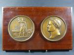 Deux grandes médailles commémoratives en bronze fixées sur un panneau...