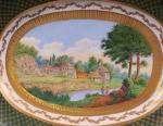 Plat ovale en porcelaine à décor polychrome d'un paysage avec...