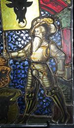Vitrail représentant un chevalier en armure sous une voute architecturée...