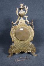Pendule en bronze doré à décor rocaille surmontée d'un vase...